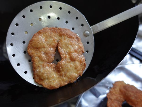 צ'ידה מוצאת מהשמן במצקת מנוקבת
